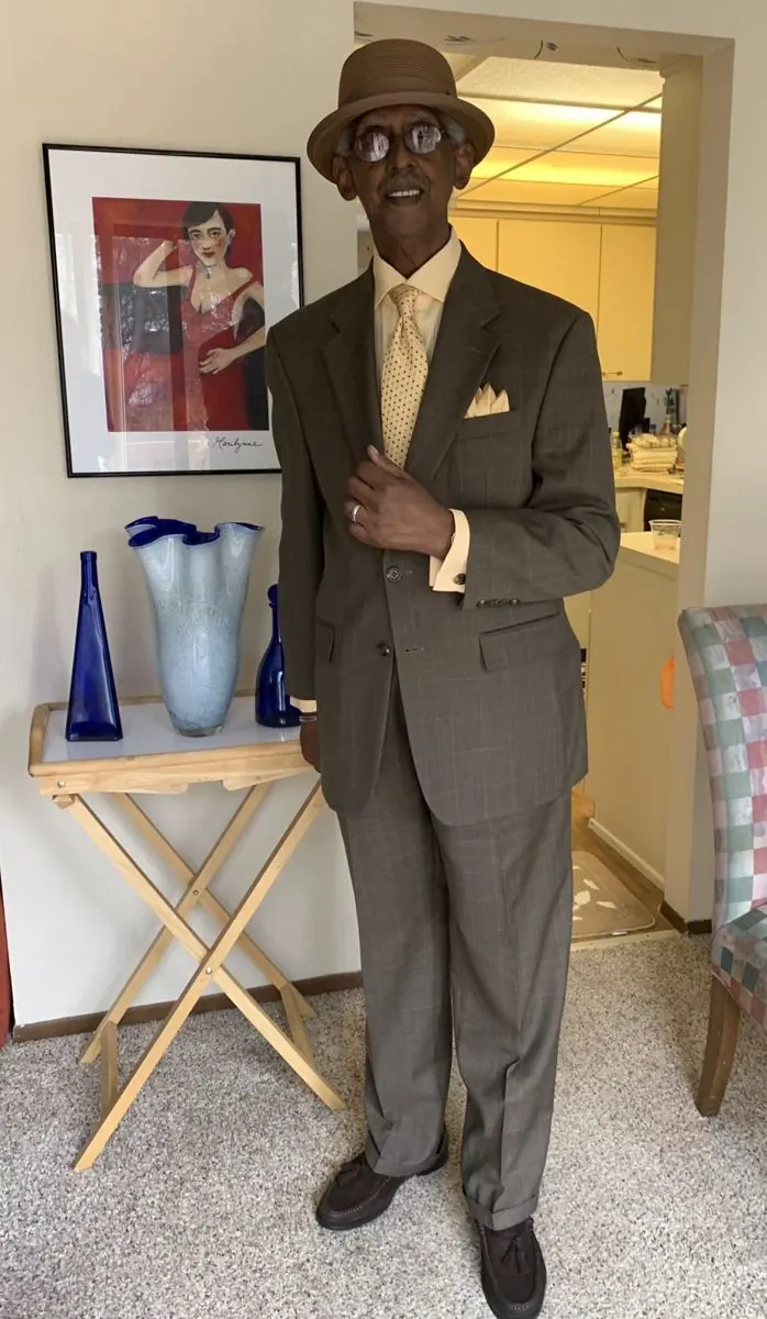 A Label Legends customer dressed in a brown windowpane suit and fedora