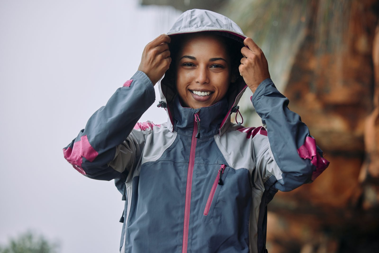 Woman pulling up the hood of a lightweight performance jacket