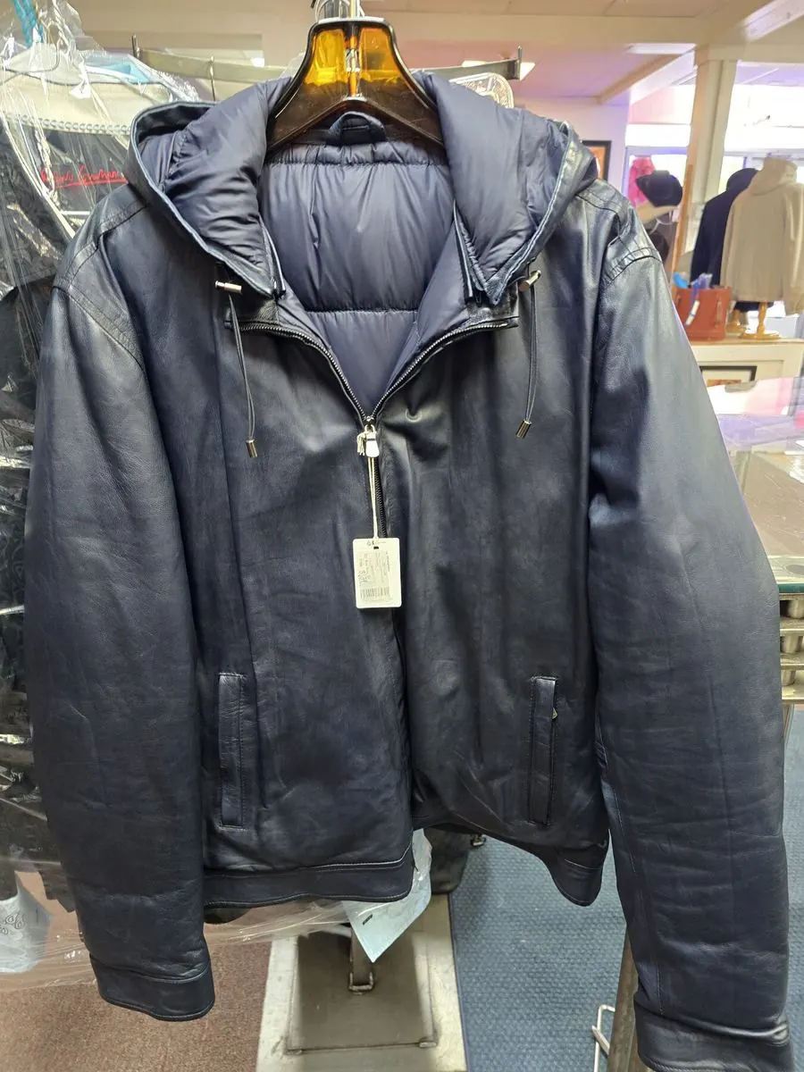 Navy quilted jacket with leather sleeves on a mannequin in the Label Legends showroom