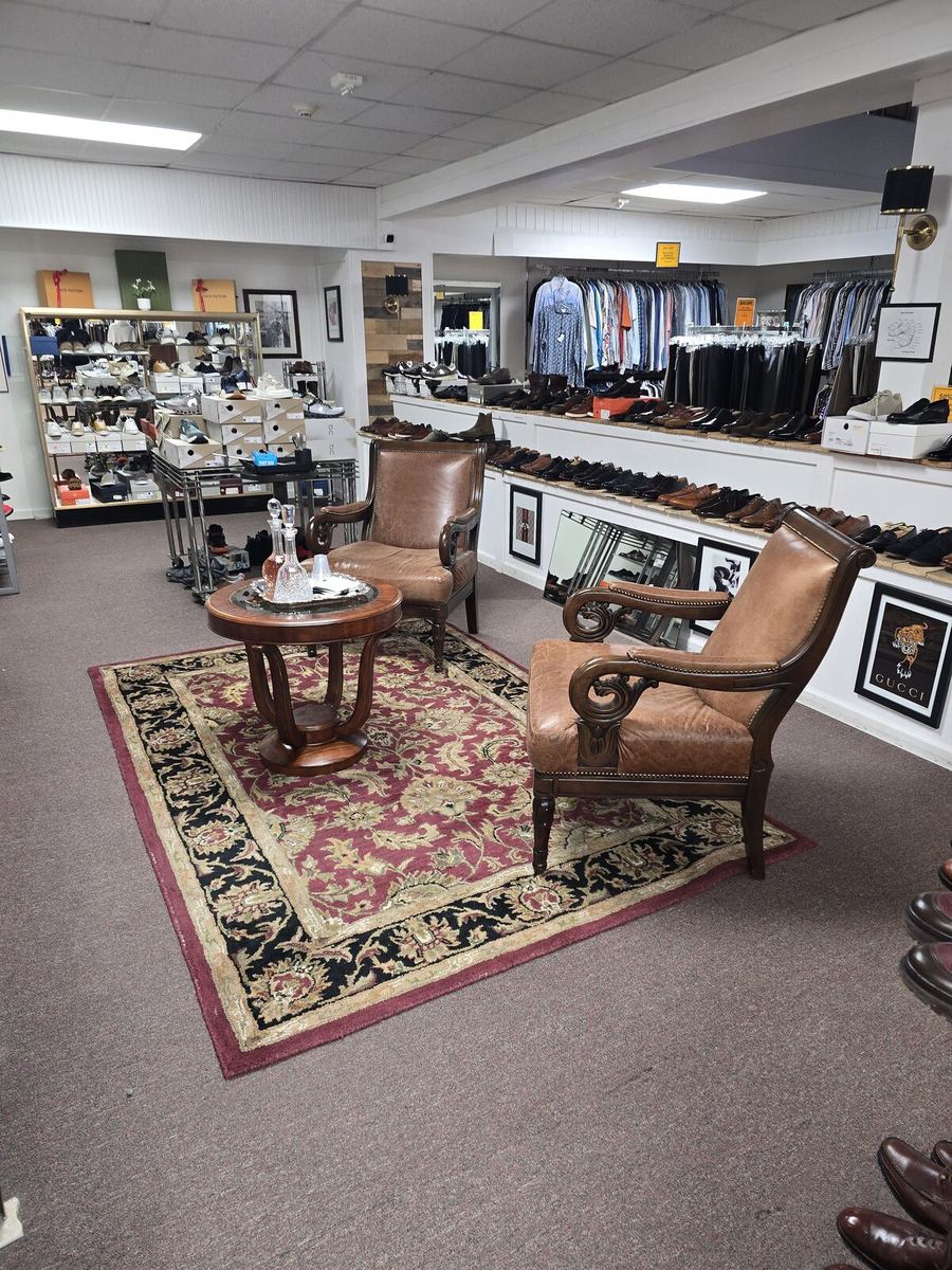 Inside the Label Legends showroom in Farmington Hills — lounge chairs beside the designer shoe wall