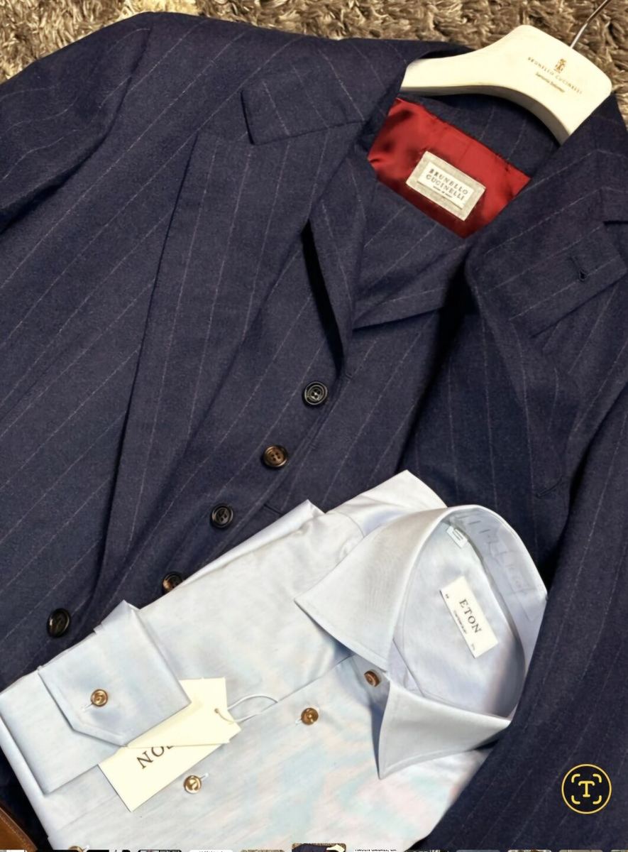 Navy pinstripe suit jacket folded with a white dress shirt at Label Legends