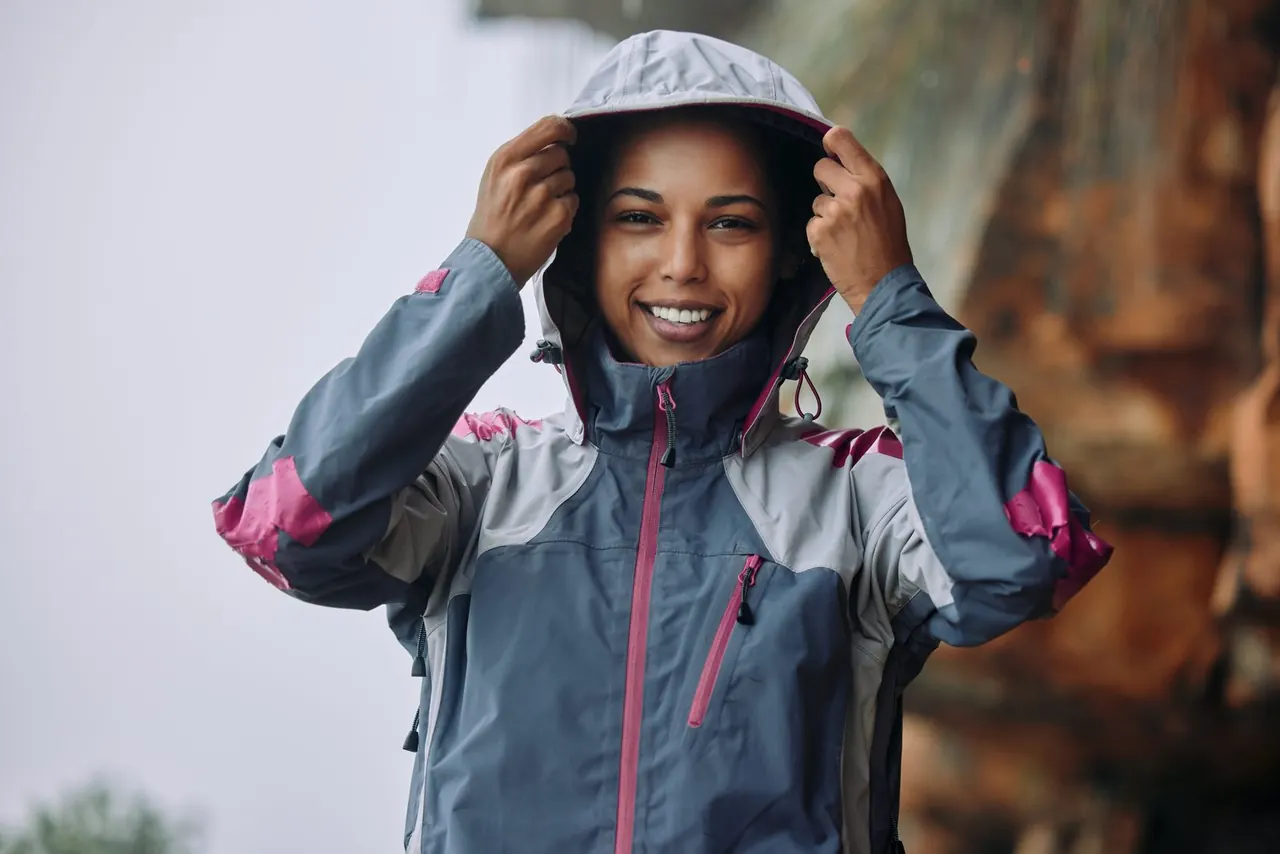 Woman pulling up the hood of a lightweight performance jacket