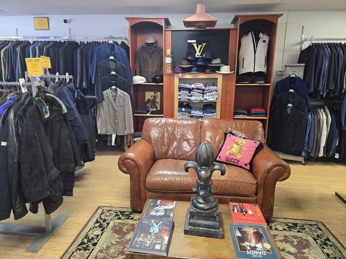 Inside the Label Legends showroom in Farmington Hills — leather seating among racks of designer coats
